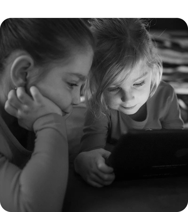 Children looking closely at a tablet